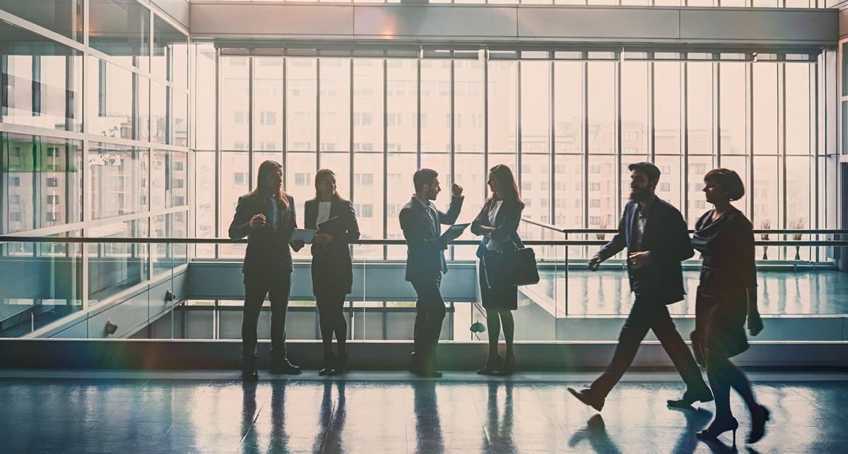 People standing on the balcony of a high-rise office building talking